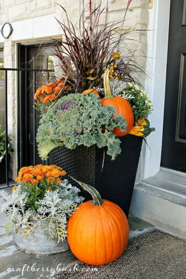 arreglos de flores y calabazas para decorar la puerta en otoño